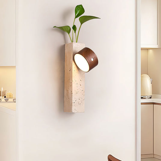 Travertine wall sconce lit in a hallway beside an open doorway