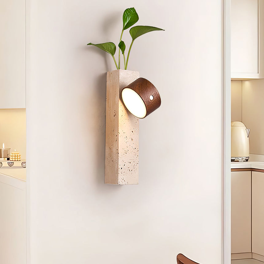 Travertine wall sconce lit in a hallway beside an open doorway