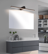 Black bar lit above a mirror over a dark vanity unit with a basin and a plant