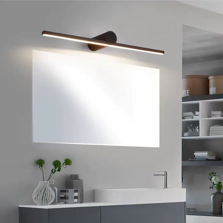Black bar lit above a wide bathroom mirror over a stone basin with a vase