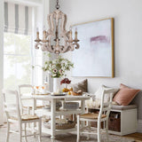 Hung over a round breakfast table and painted chairs beside a cushioned bench
