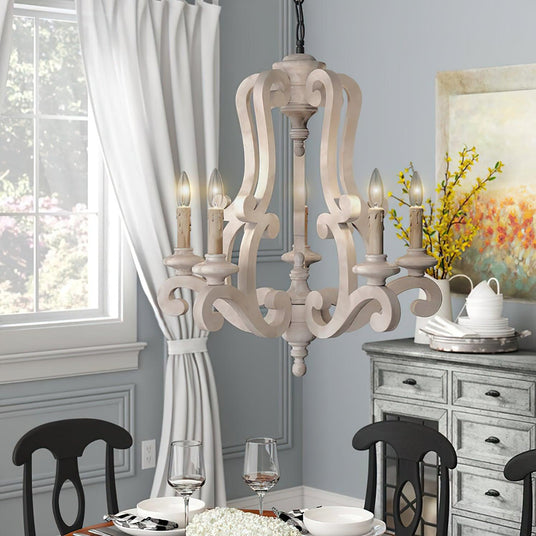 Lit above a set dining table beside a long curtain and a painted sideboard
