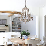 Seen over a round table in an open room with bookshelves and a fireplace beyond