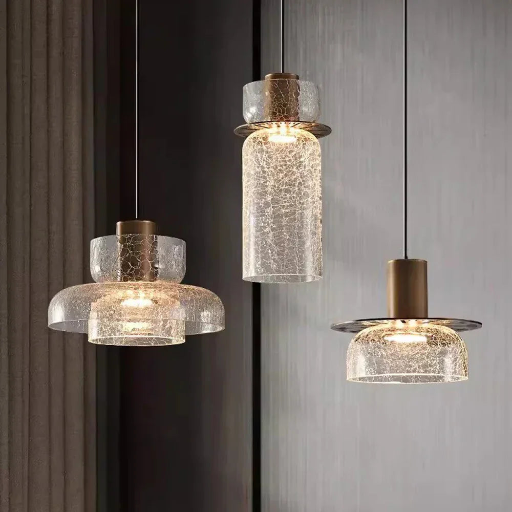 Three crackle glass shades of different heights lit on brass caps