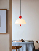 The cream dome lit above a table against a deep blue wall with artwork
