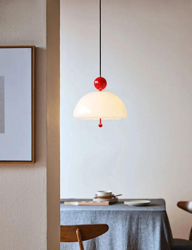 The cream dome lit above a table against a deep blue wall with artwork