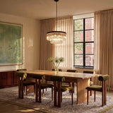 The round gold version above a dining table with green chairs and a window