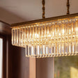 A gold linear frame packed with elongated crystal prisms lit from within