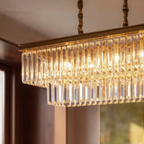 A gold linear frame packed with elongated crystal prisms lit from within