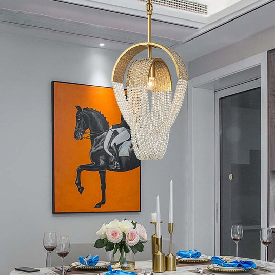 The small pendant version lit above a dining table set with roses and candles