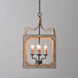 The cube frame lit against a pale wall, four candle lamps burning inside
