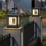 A row of lit cubes along pillars above a dark fence in a garden