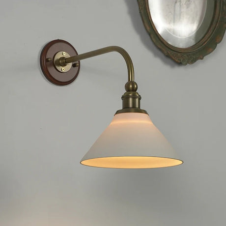 The round wood wall plate and the brass socket above the white cone