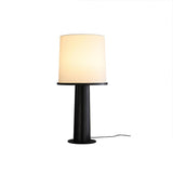 The black version of the cylinder table lamp, lit front view