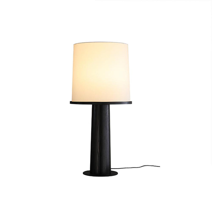 The black version of the cylinder table lamp, lit front view