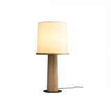 The light wood version of the cylinder table lamp, lit front view