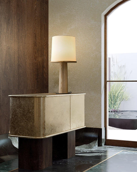 Cylinder table lamp lit on a metal cabinet by a doorway