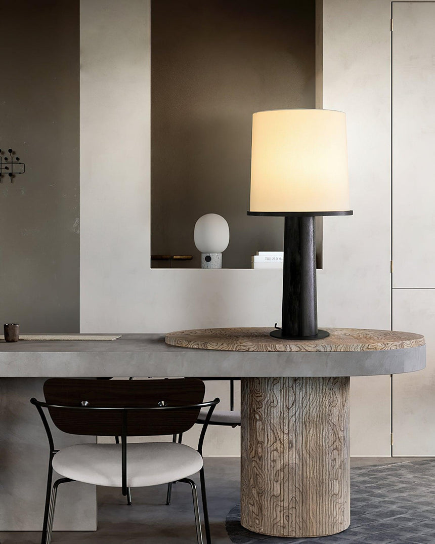 The black version lit on a stone table beside dining chairs