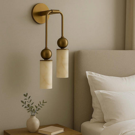 The light lit beside a bed with white pillows and a small nightstand