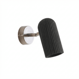 Fluted black cylinder angled out from its brushed nickel wall plate