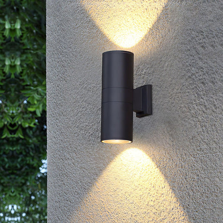 The black cylinder lit on a textured wall, beams of light above and below