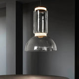 The stacked glass cylinder pendant lit against a dark painted wall