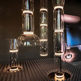 Several stacked cylinder pendants lit above a patterned table setting
