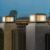 A row of caps lit along a low wall and its pillars at dusk