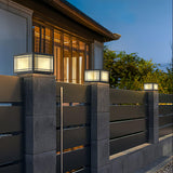 The cap glowing on a pillar beside a timber clad house at dusk