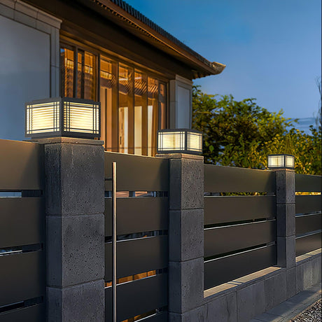 The cap glowing on a pillar beside a timber clad house at dusk