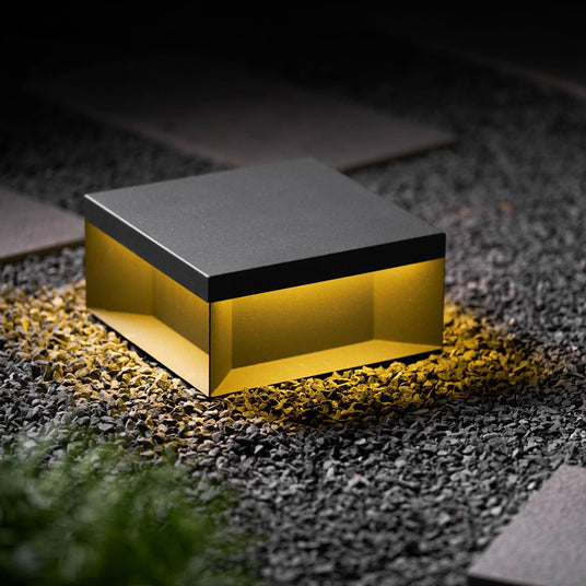 Two boxes marking the edge of a gravel path beside garden planting