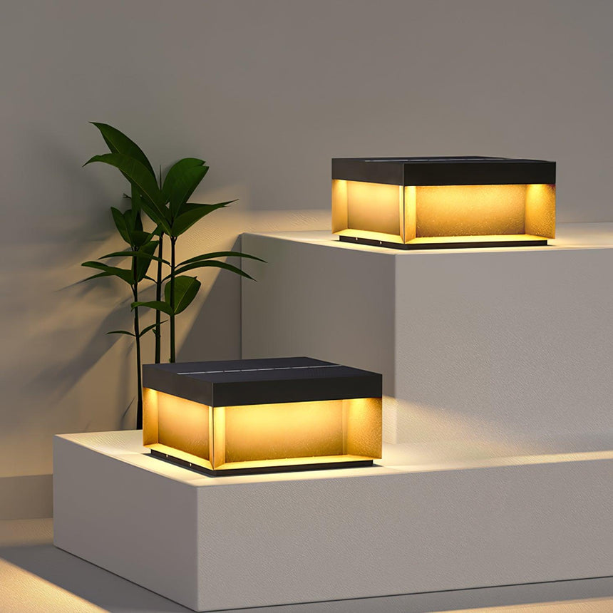 Two flat post lights glowing on pale garden steps beside a potted plant