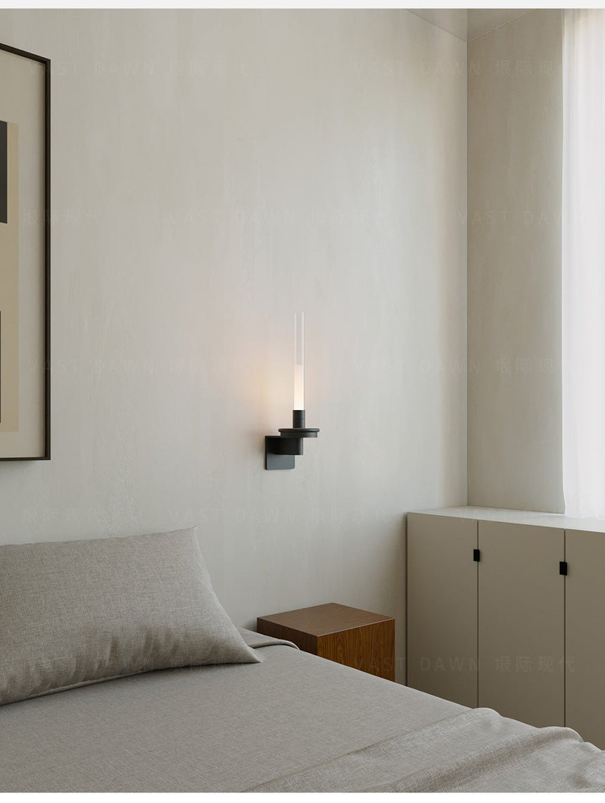 Lit above a bed beside a pale cabinet, the stem reading as a thin line
