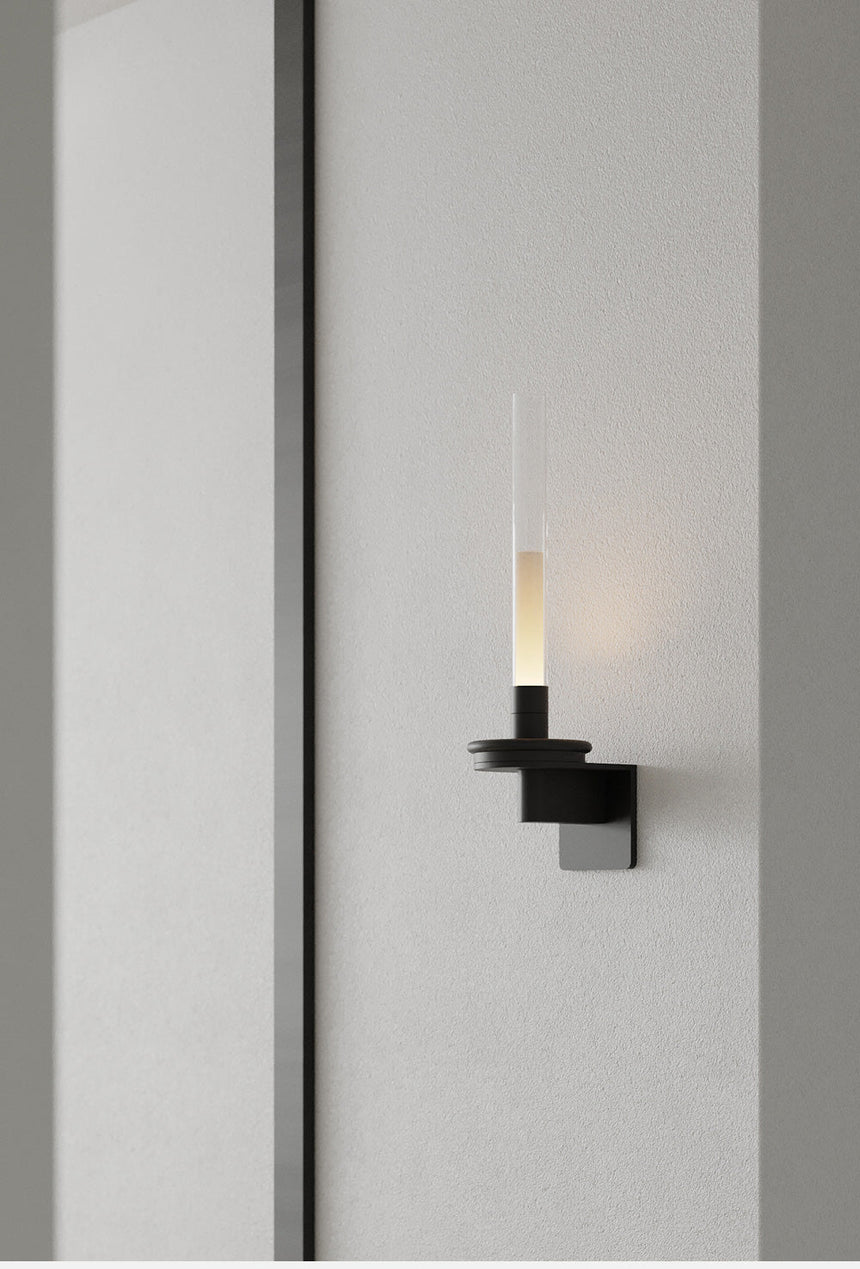 Lit warm in a corridor, the stem casting a soft pool down the gray wall