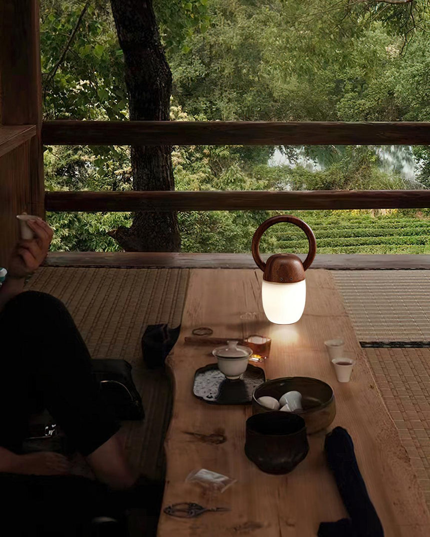 Dimmable bedside lamp lit on a long wooden table set with bowls