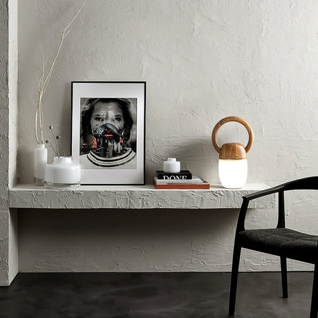 Dimmable bedside lamp lit on a plaster shelf beside a framed print