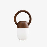 Dimmable bedside lamp in walnut lit against a plain pale ground