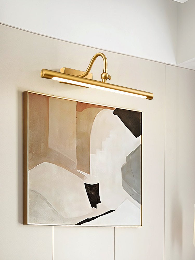 Brass bar seen from the side, lit above a framed canvas in a corner