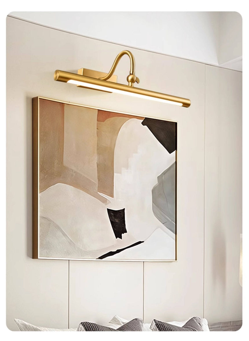 Brass bar lit over a framed artwork on a paneled wall above a cabinet