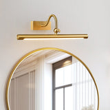 The curved arm version lit above a round gold mirror beside a window