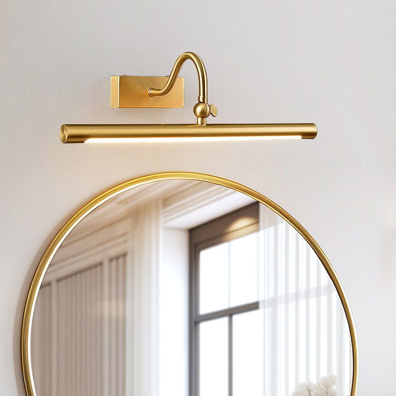 The curved arm version lit above a round gold mirror beside a window