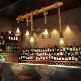 Beam chandelier lit above a long counter lined with bottles and shelves