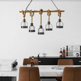 The beam lit above a marble island with tan chairs pulled up to it