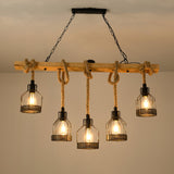 Chandelier lit close to a warm ceiling, cages and rope in full view