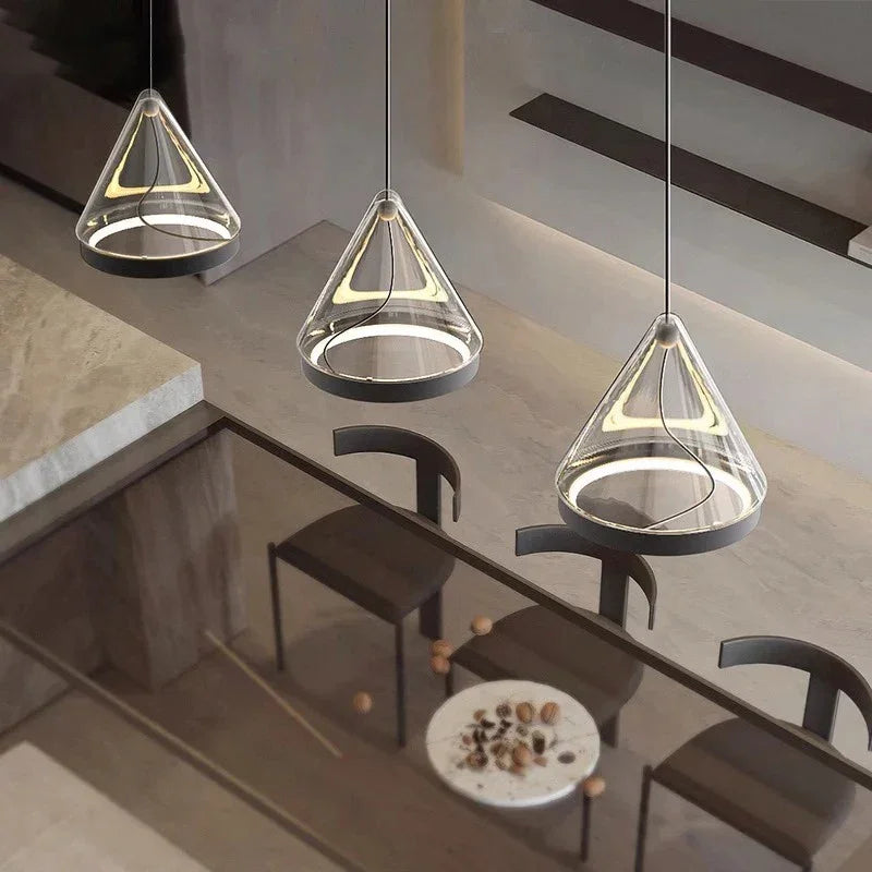 Three amber cone pendants hung at different heights beside a stair rail