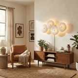 The disc light glowing above a walnut sideboard beside a leather armchair and plants