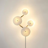 Four discs lit on a curving stem, the light pooling around each edge