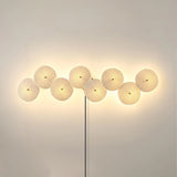 Eight discs in a long horizontal row glowing on a warm wall
