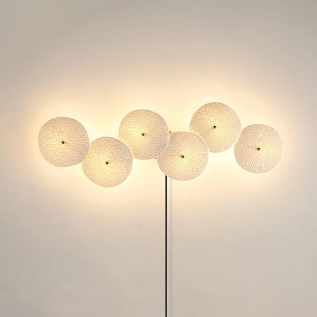 Six discs in a horizontal row, lit, the cord dropping from the center