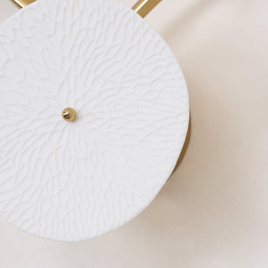 Close view of the pressed petal pattern on a white ceramic disc